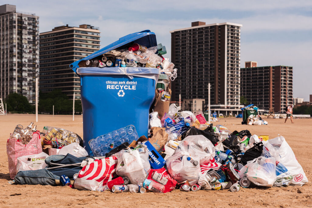 Mounds of trash piled next to a trashcan on Kathy Osterman Beach - Chicago Lakefront photography by Michael Courier